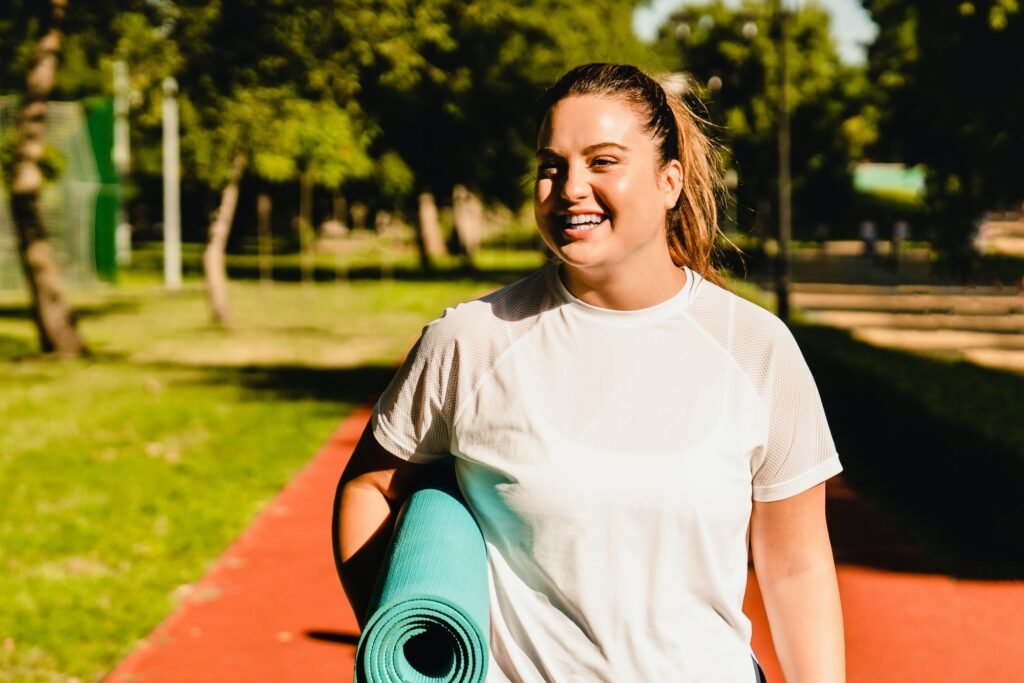 Fat athlete in fitness outfit preparing before yoga training stretching workout on mat