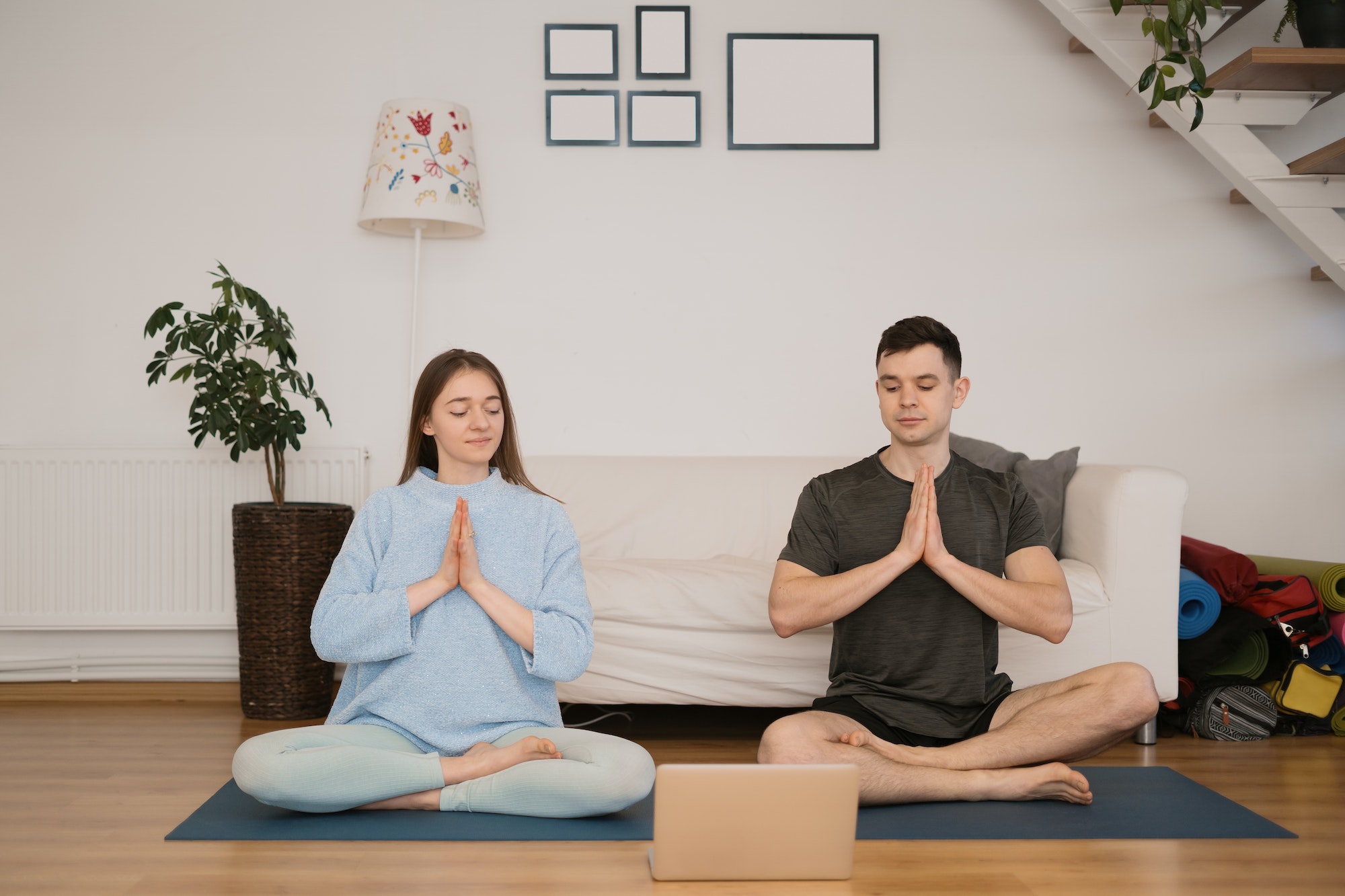 Beautiful couple practicing online yoga classes