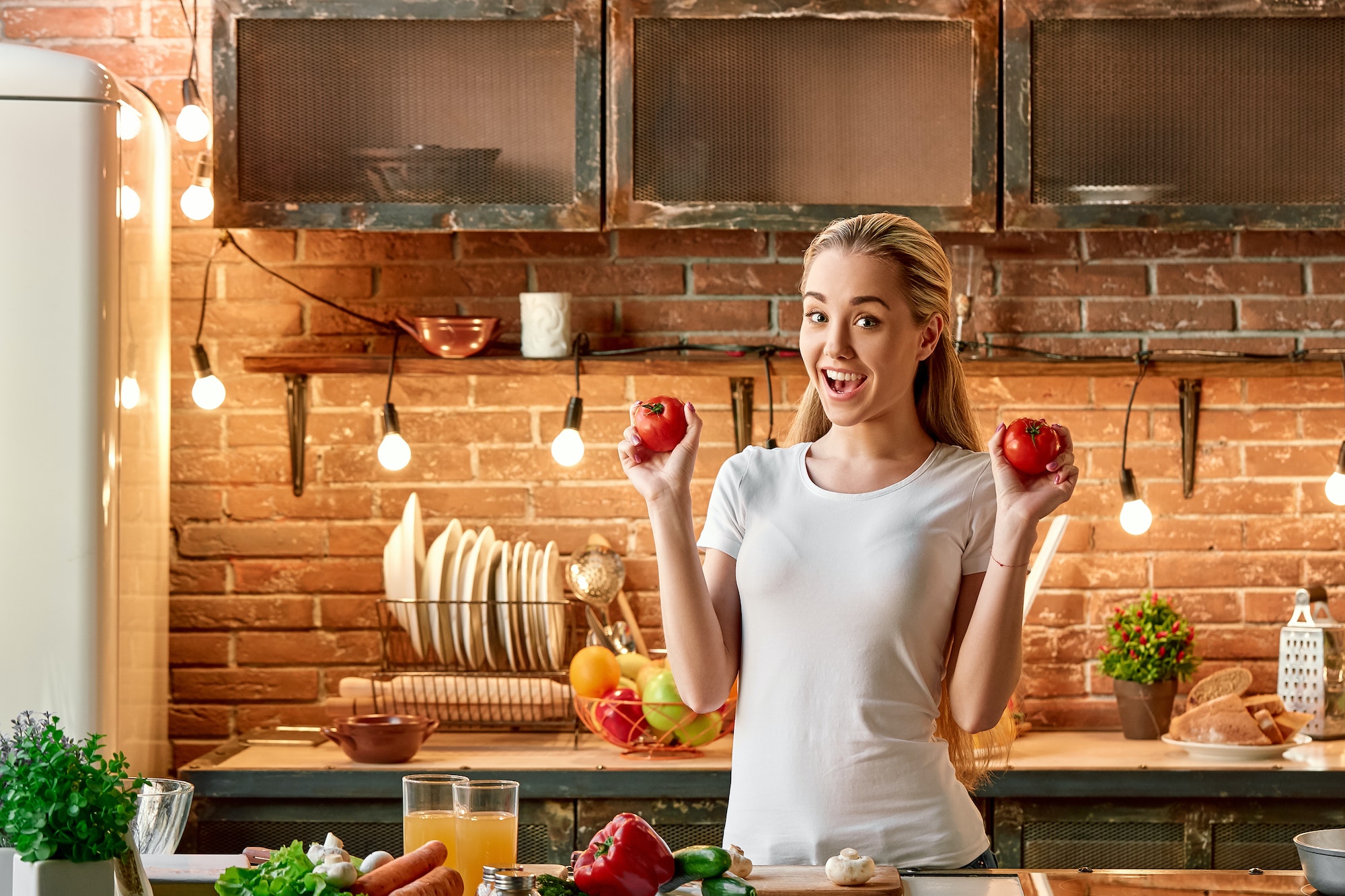 Culinary and Cooking Wellness Retreats, young woman cooking vegetables in modern kitchen. Cozy interior