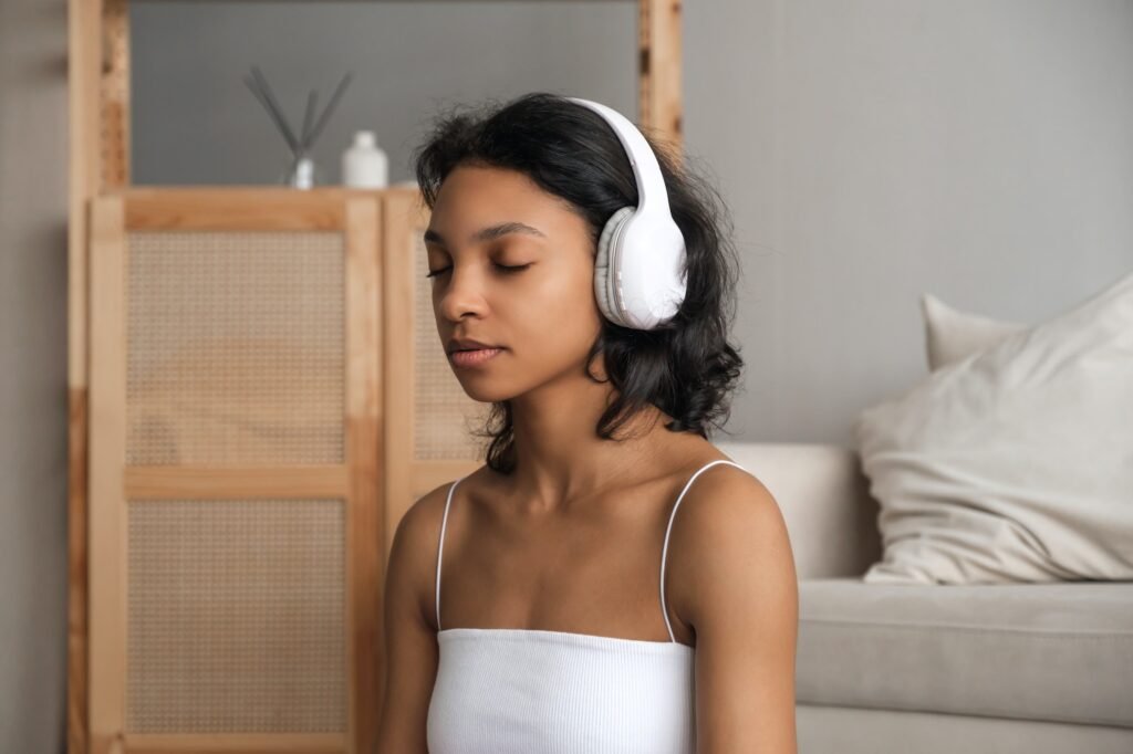 Wellbeing and wellness concept banner with relaxed young woman meditating in headphones