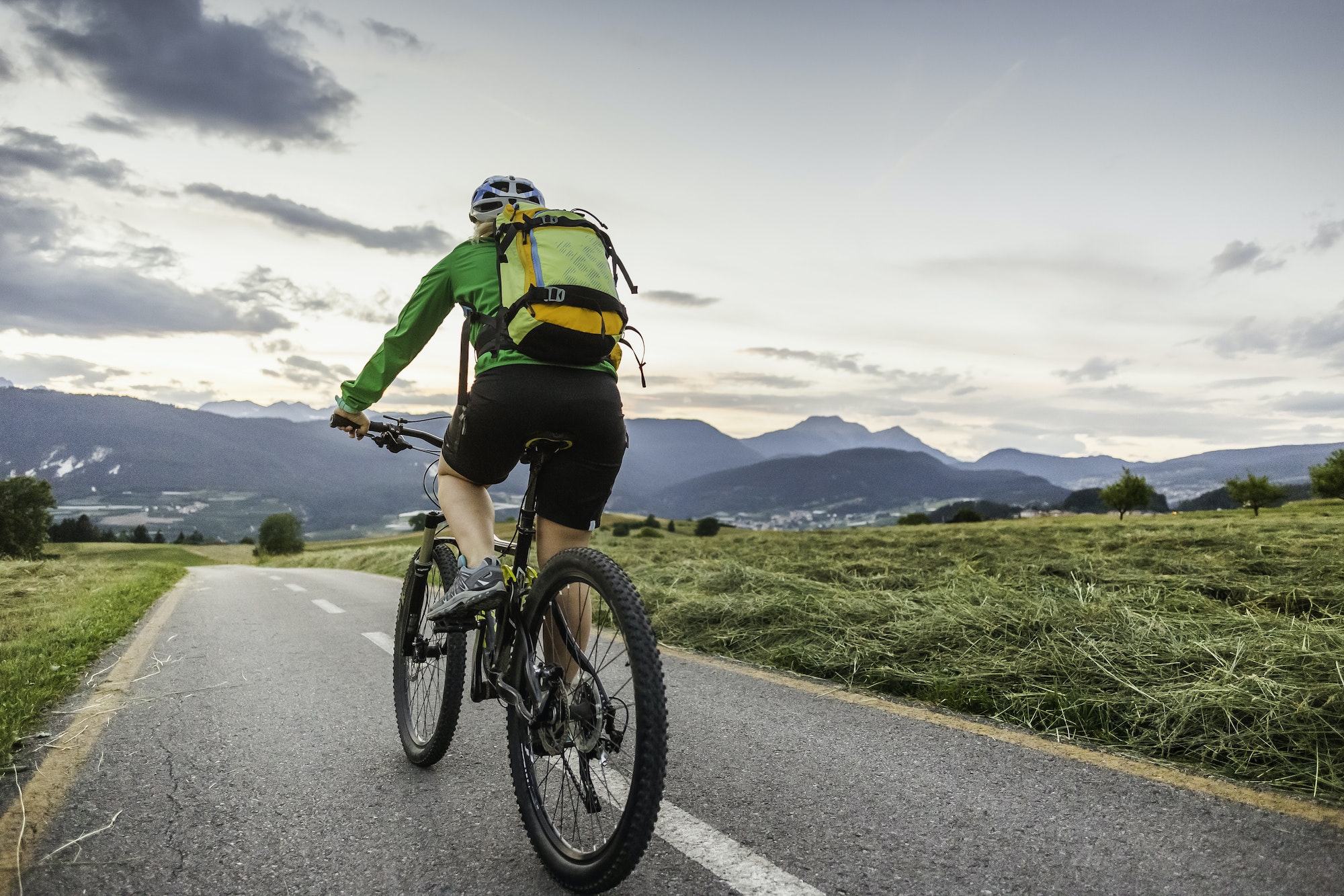 Woman cycling on road, Fondo, Trentino, Italy