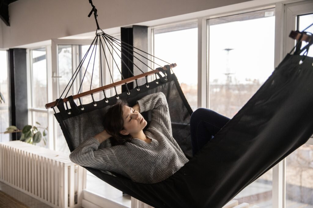 Tired woman sleeping in cozy hammock in flat