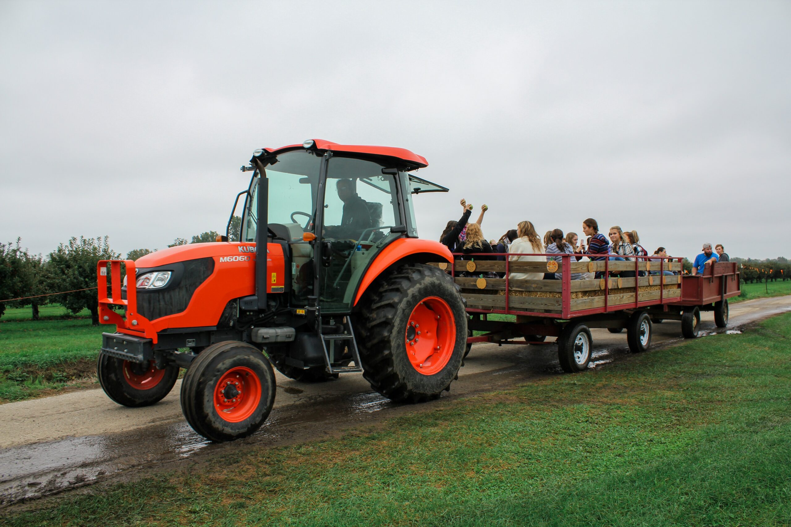 Tractor with people visiting farmland in cart
