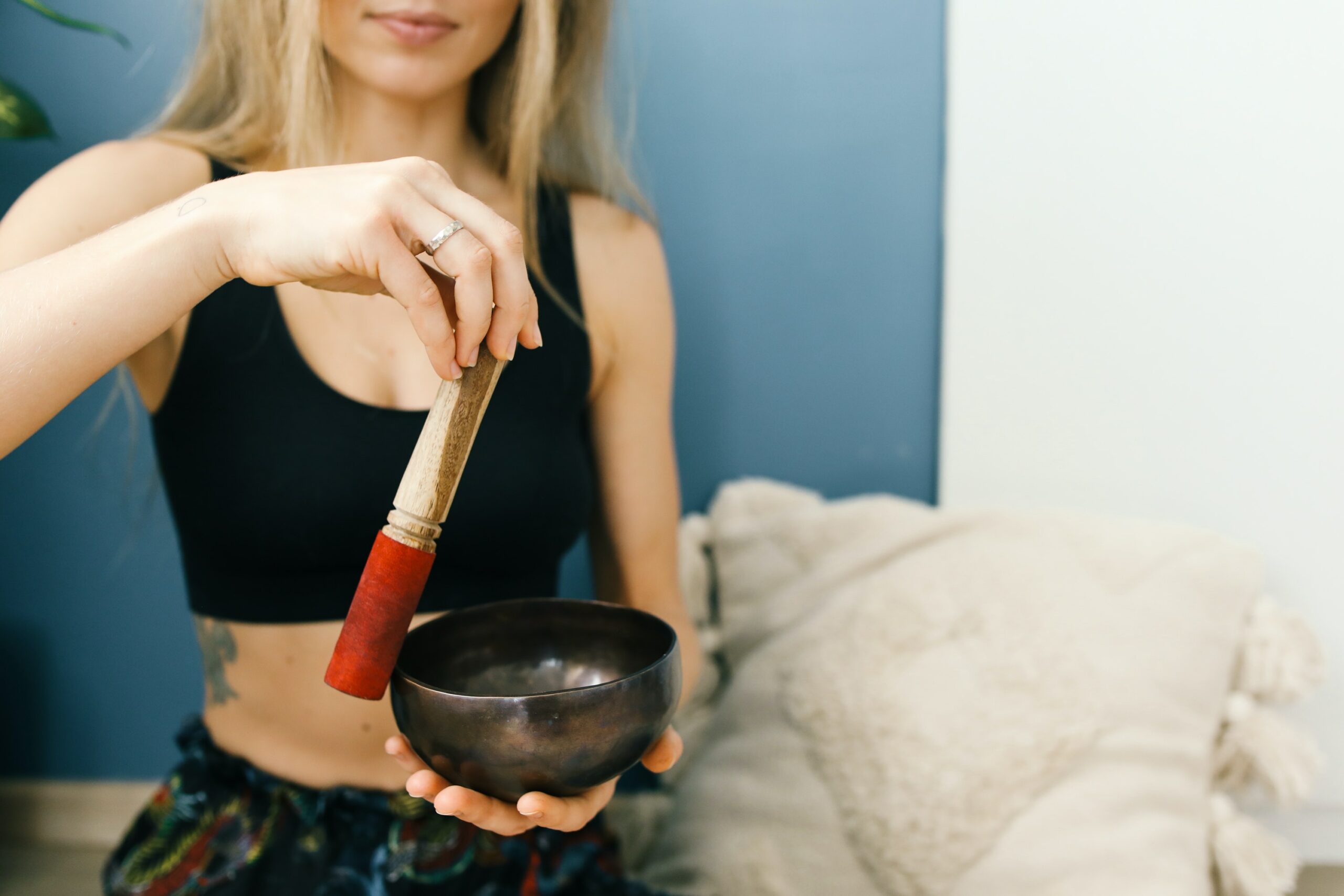 Hands Circling the Wooden Mallet on Tibetan Singing Bowl