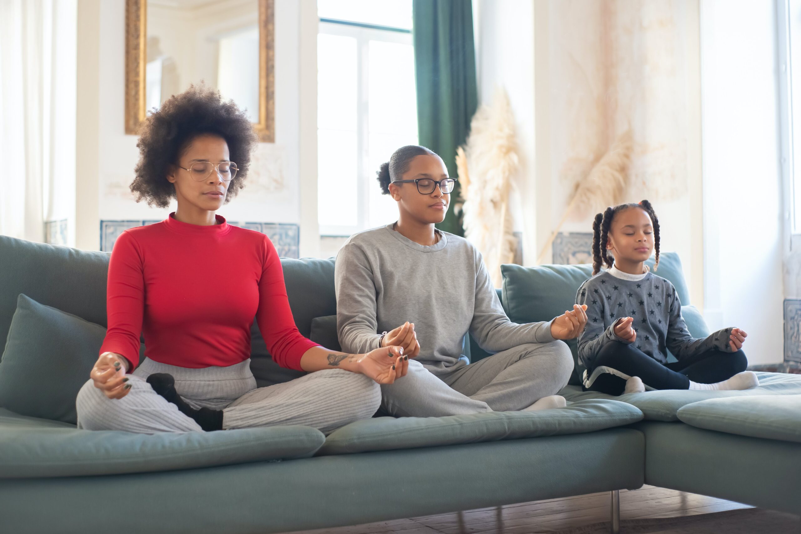 Family Sitting on Sofa While Meditating