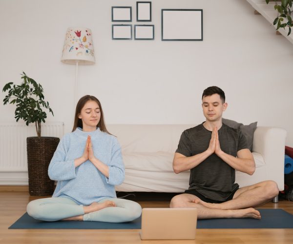 Beautiful couple practicing online yoga classes