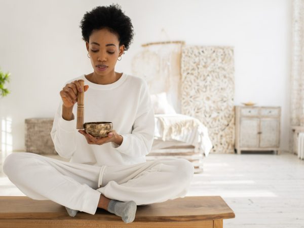 A Woman Using a Singing Bowl while Sitting