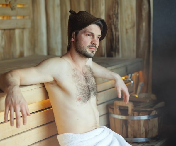 Serious man having a sauna bath in a steam room